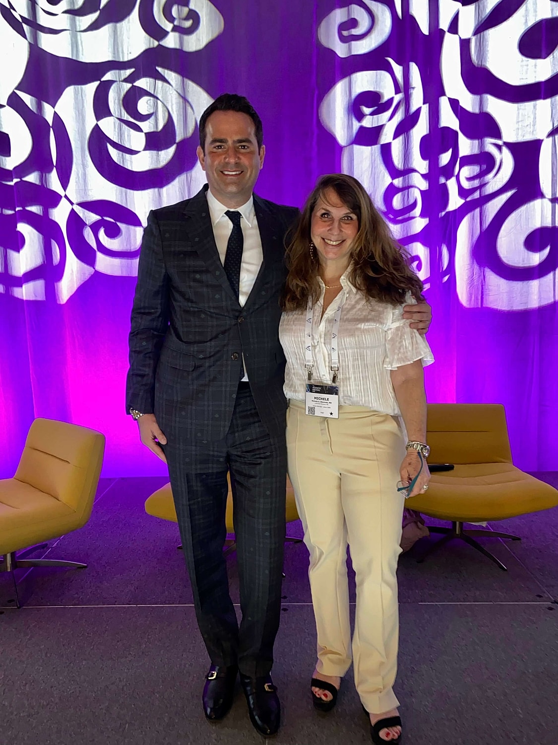 Two people posing at a conference event.