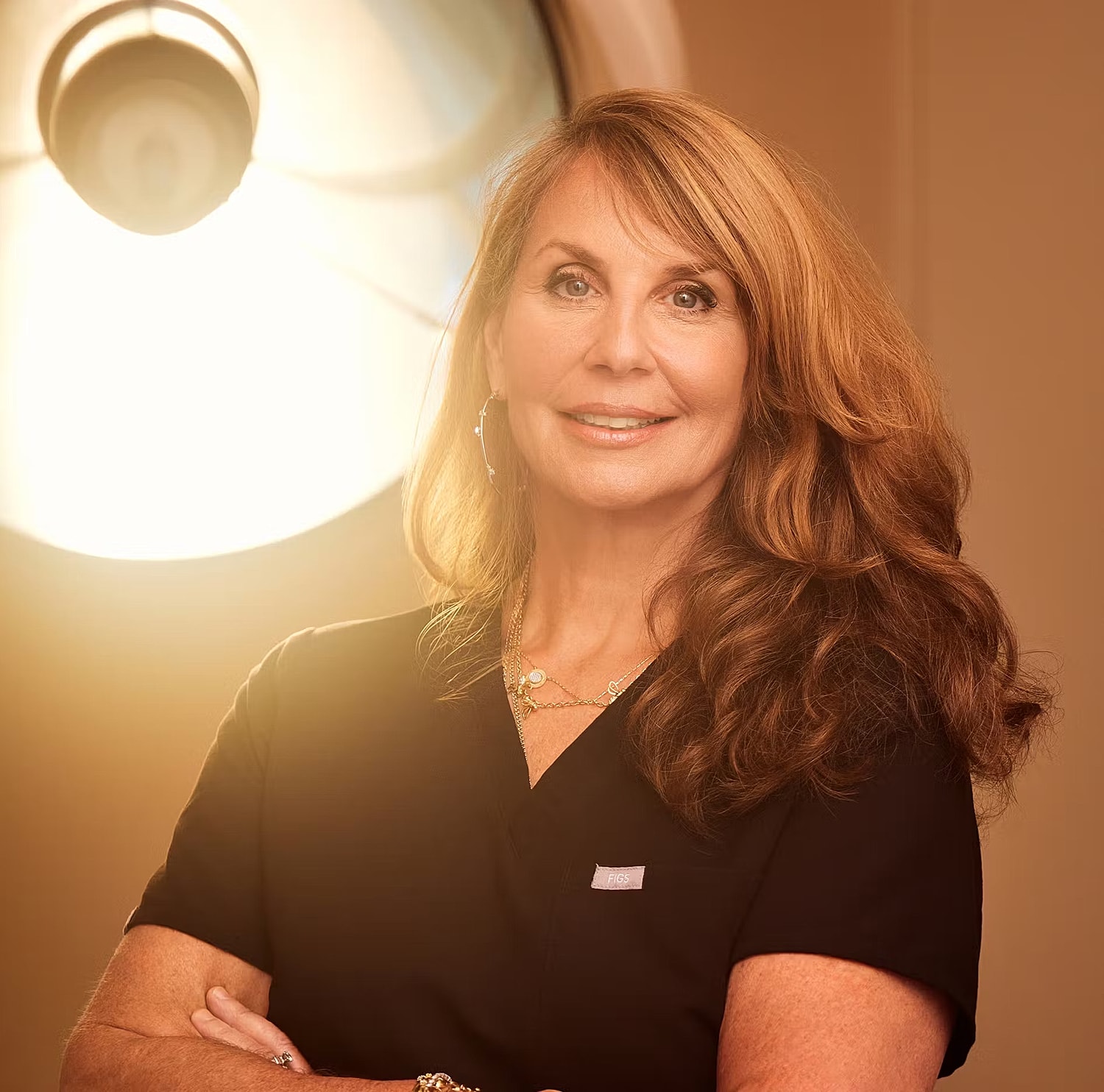 Professional woman in medical attire, smiling confidently.