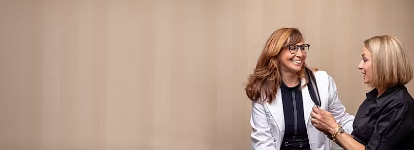 Two women smiling and interacting together.