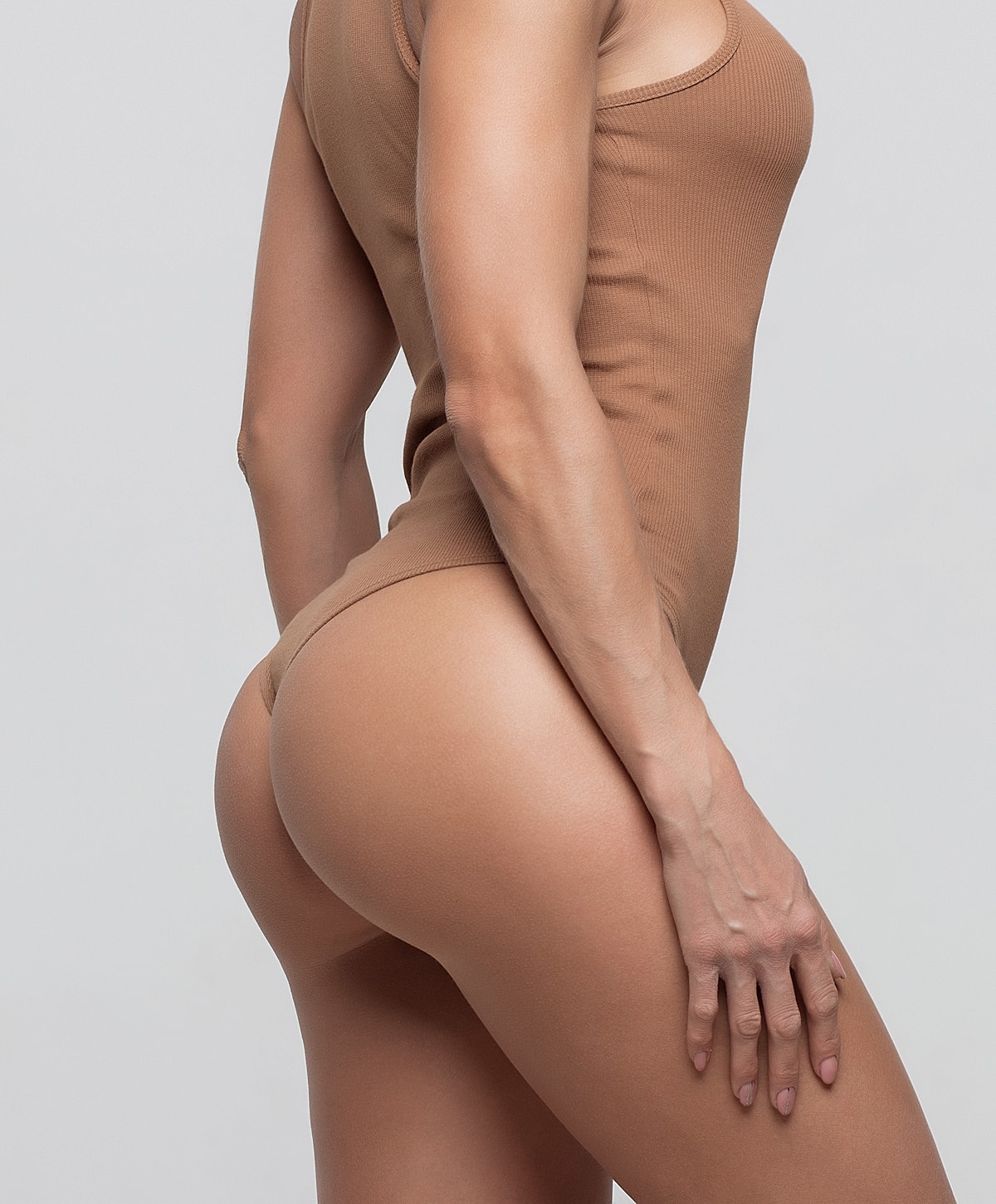 Model in brown swimwear posing confidently.