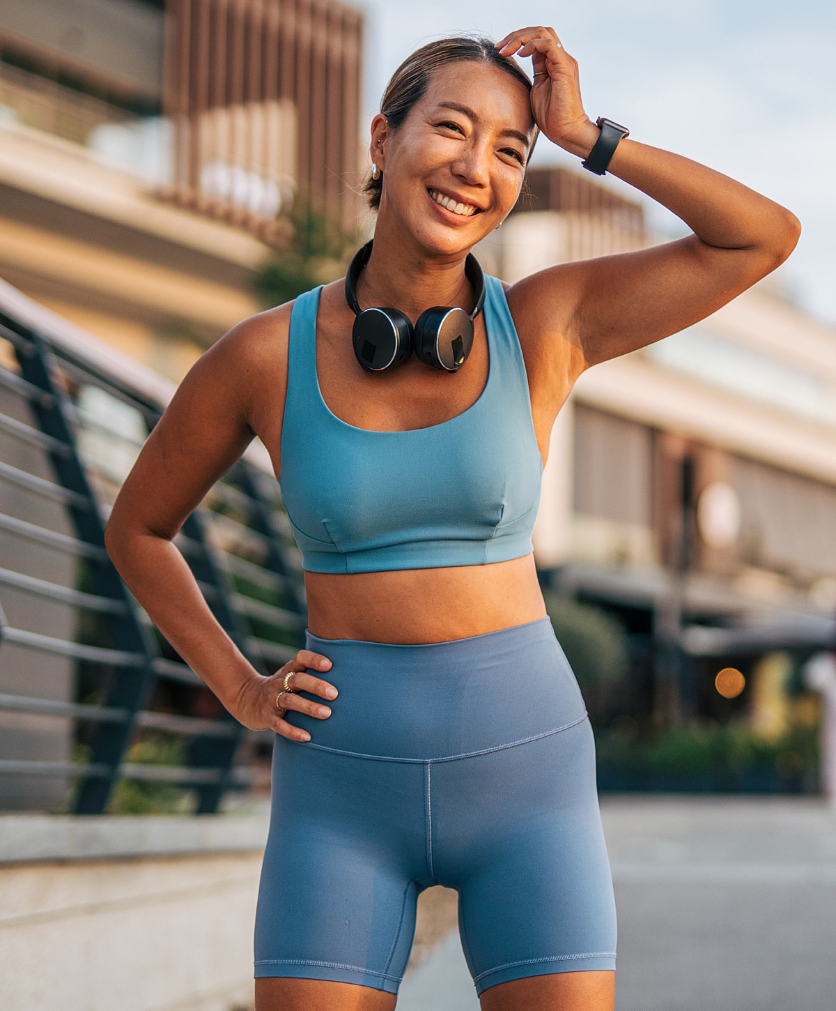 Smiling woman in workout clothes outdoors.