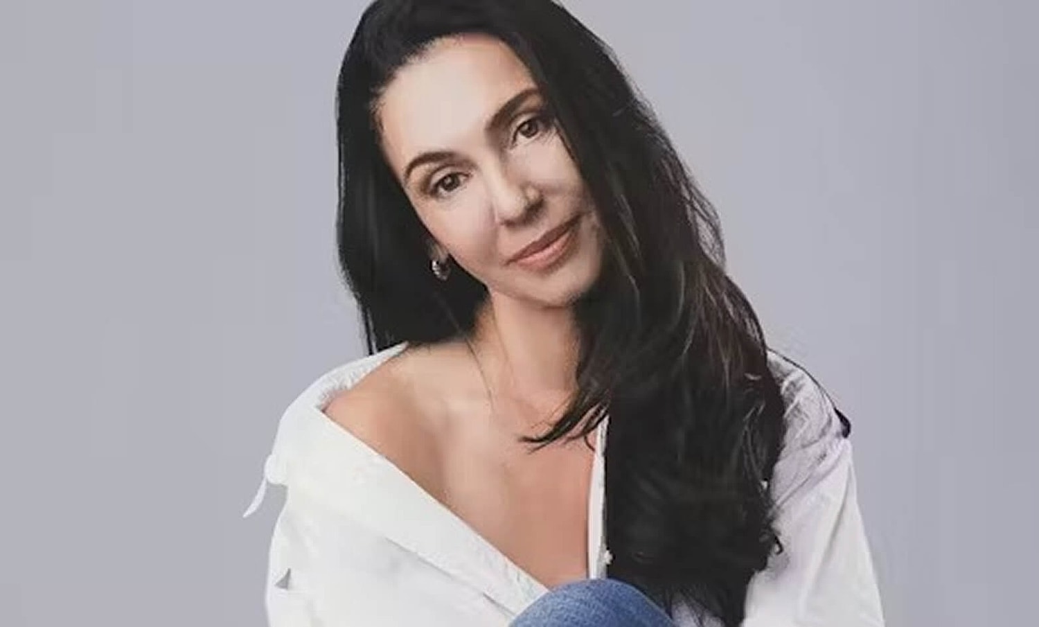 Woman in casual pose, wearing white shirt.