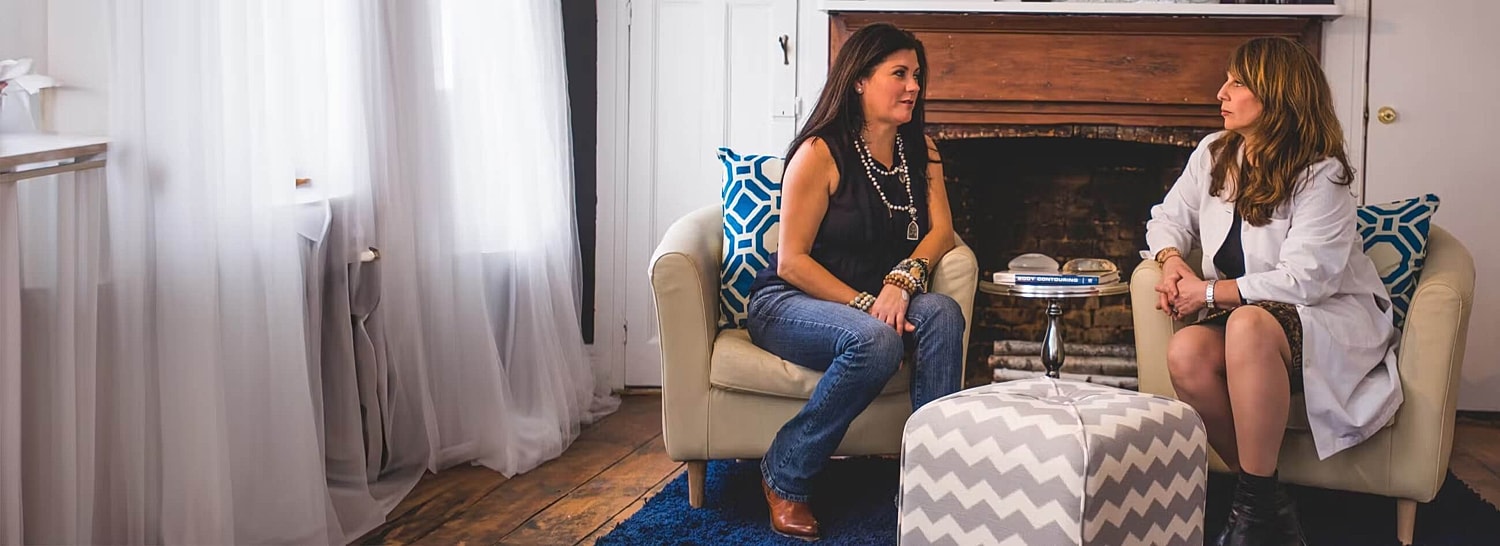 Two women talking in a cozy living room.