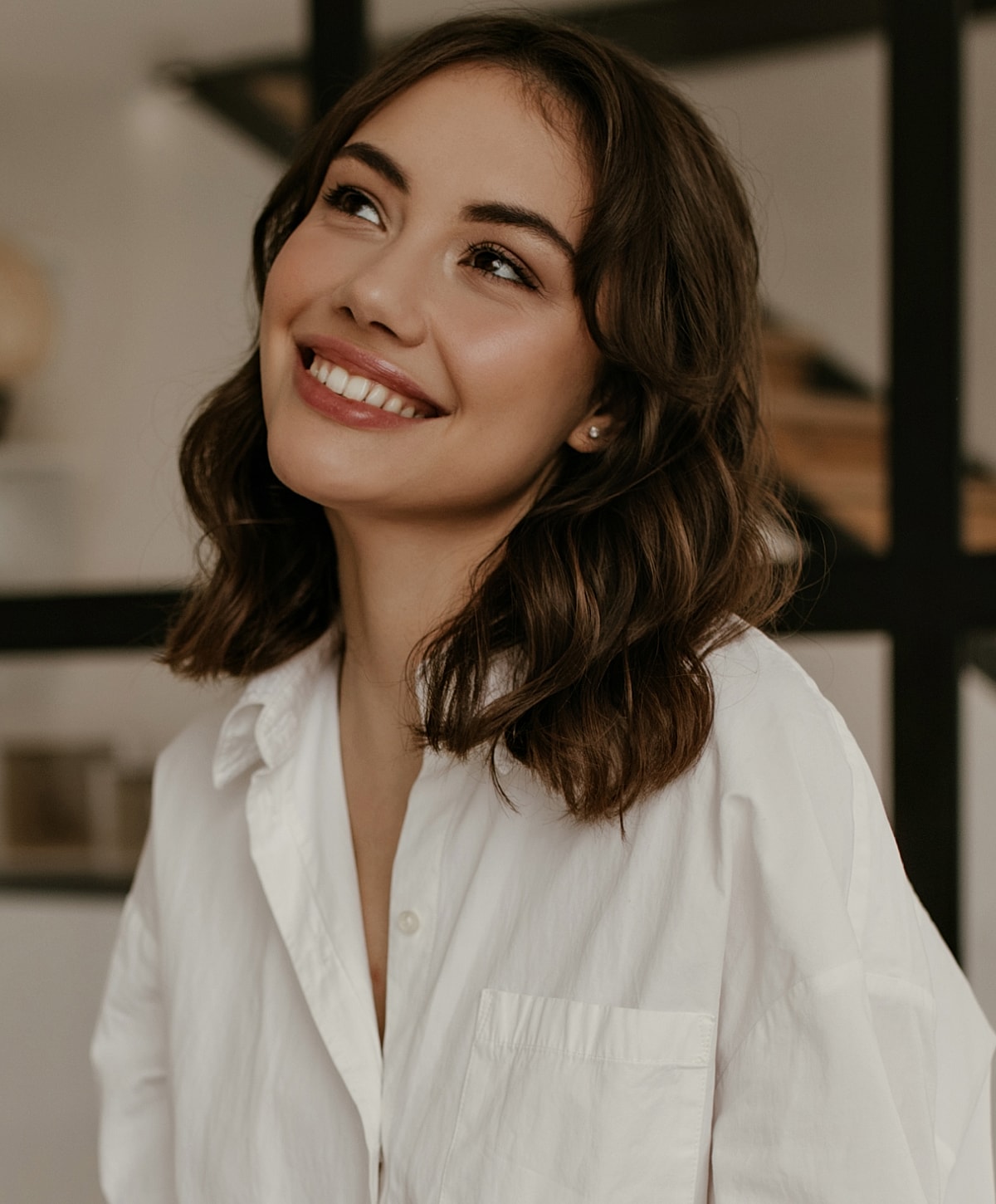 Smiling woman in a white shirt indoors.