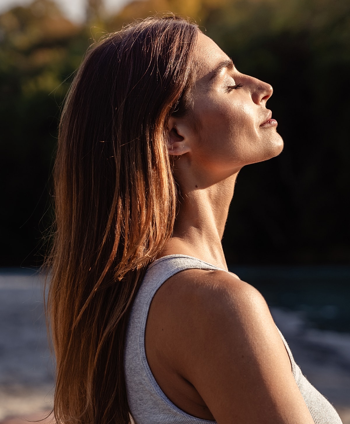 Woman enjoying sunlight with serene expression.