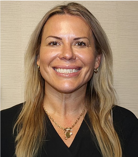 Smiling woman with long blonde hair and jewelry.