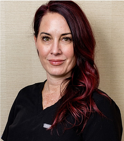 Professional woman with red hair in scrubs.