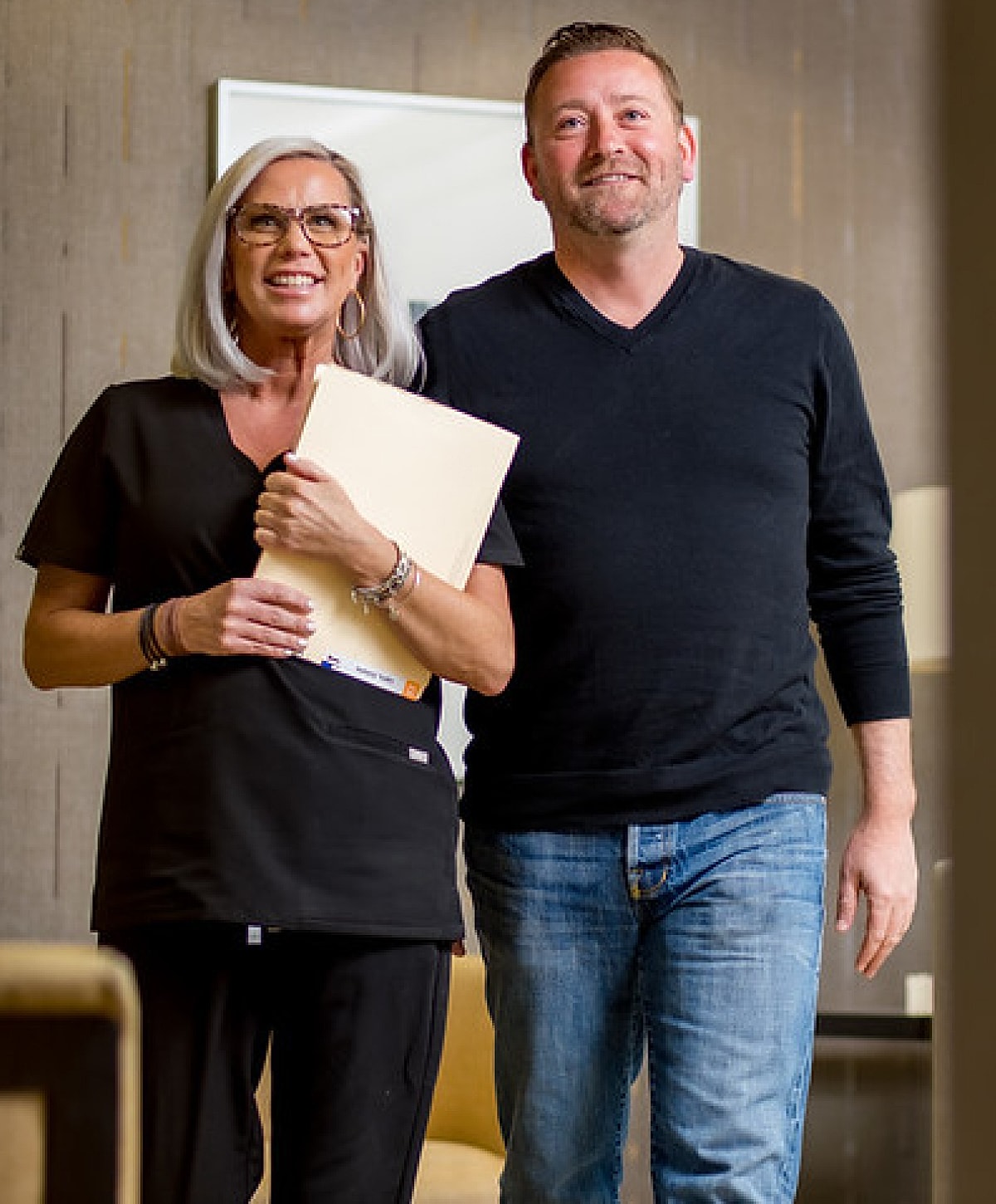 Smiling professionals walking in an office setting.