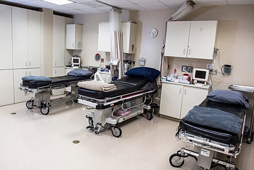 Empty hospital examination room with medical equipment.