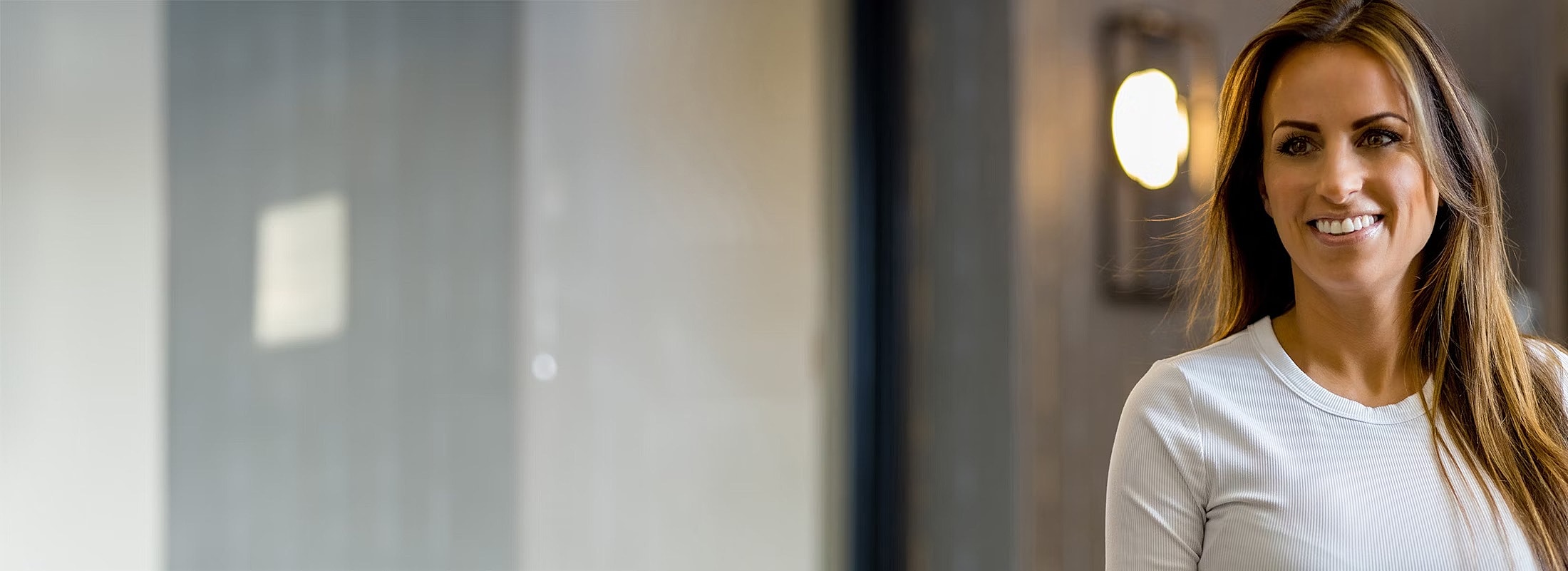 Smiling woman in a modern indoor setting.
