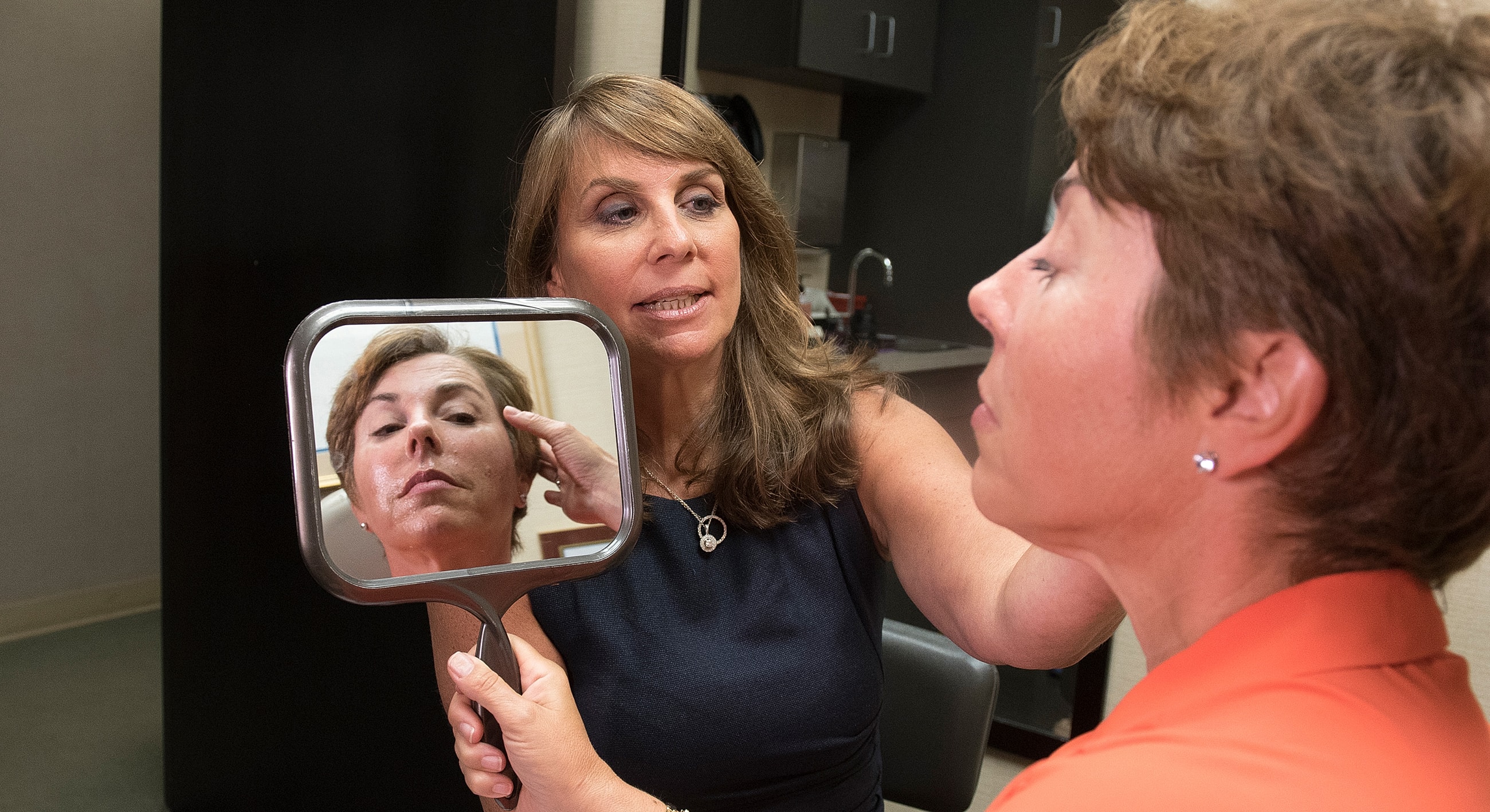 Consultation in beauty treatment with mirror reflection.