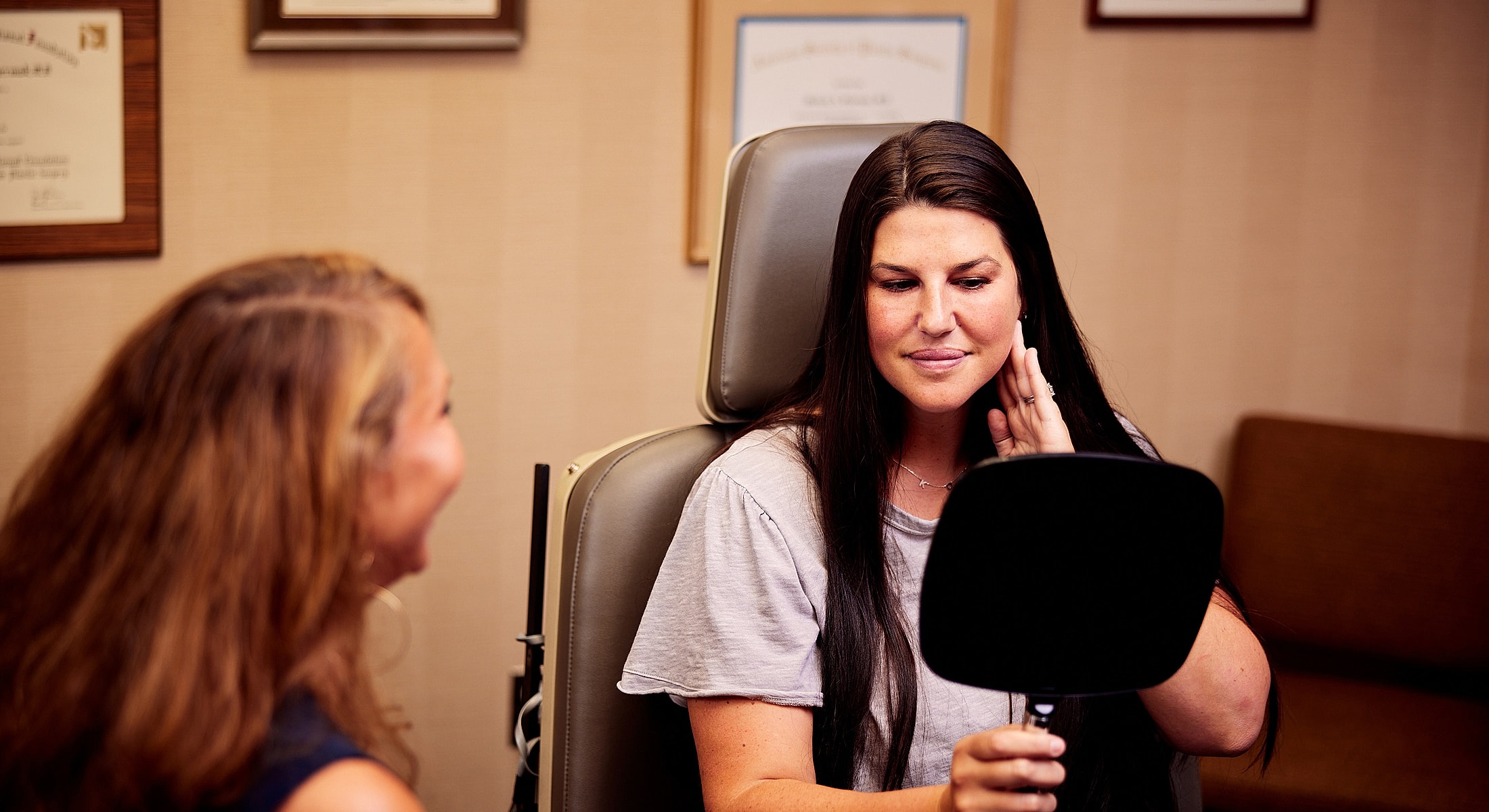 Patient examining her face in a mirror.
