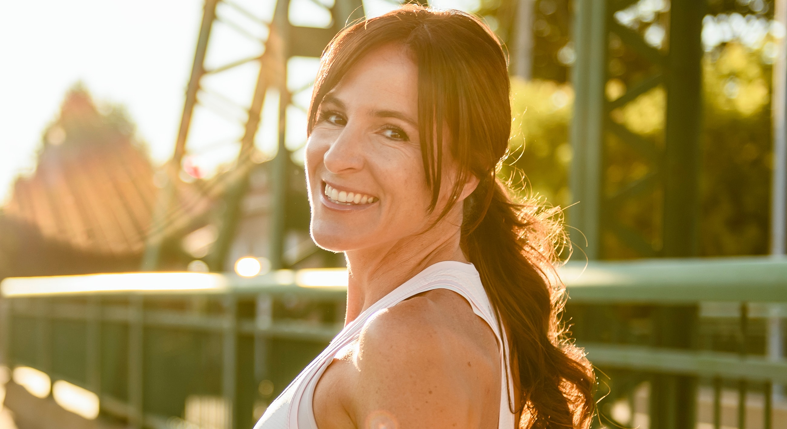 Smiling woman enjoying a sunny, outdoor moment.