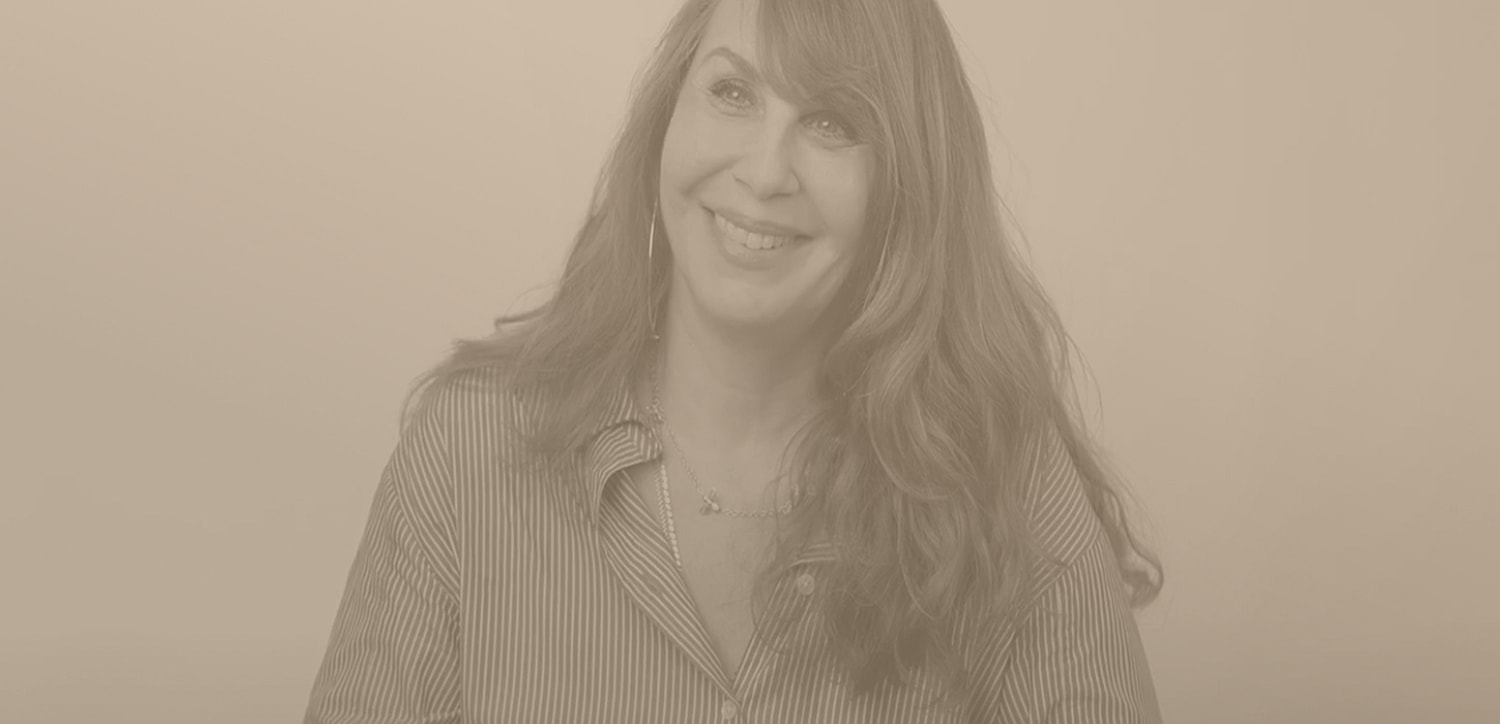 Smiling woman with long hair in casual attire.
